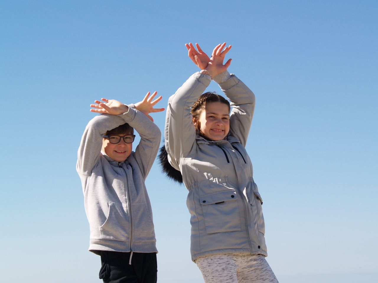 Services Two children having fun under a clear blue sky, expressing joy and freedom.